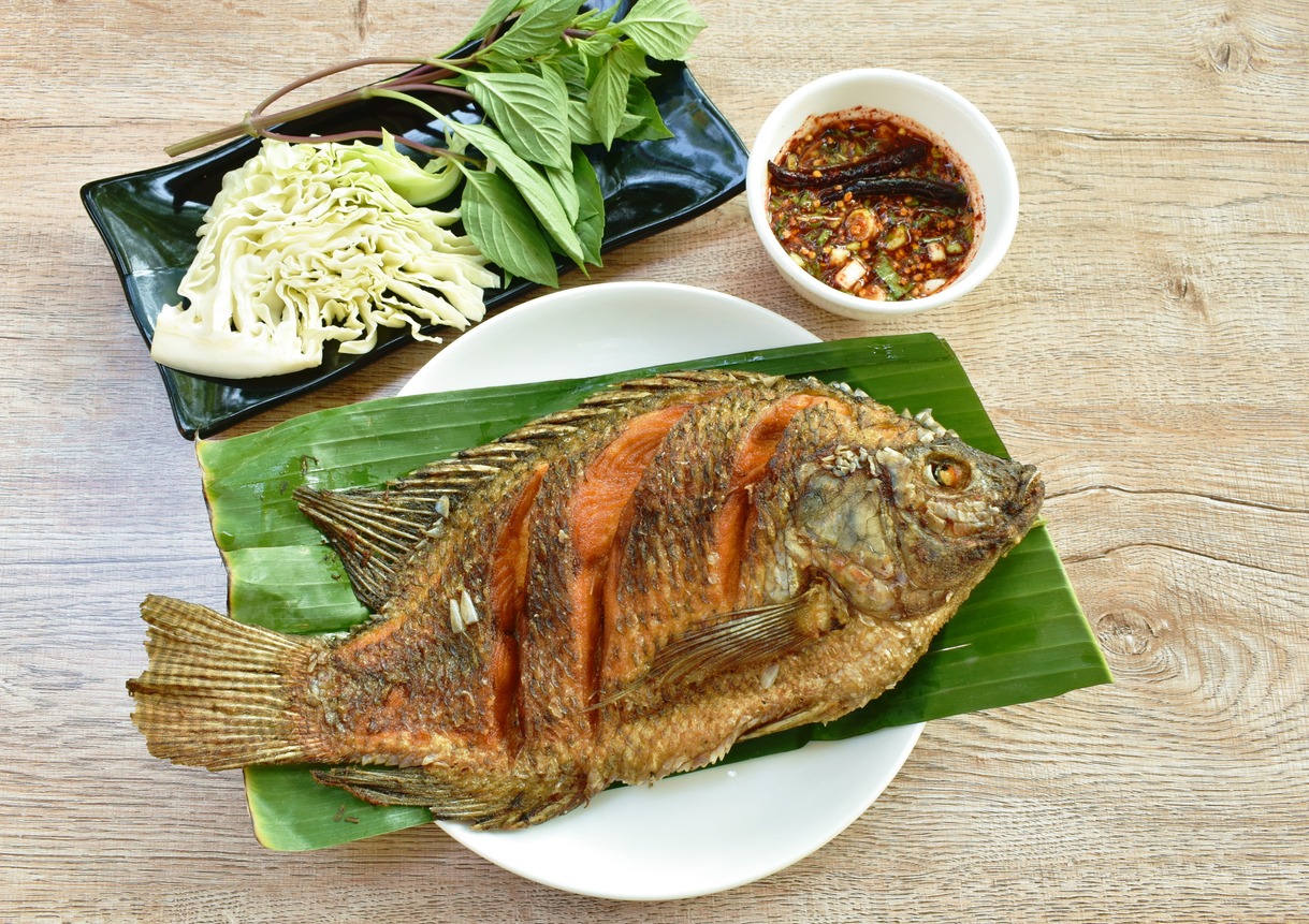 fried mango fish dressing spicy sauce and fresh vegetable