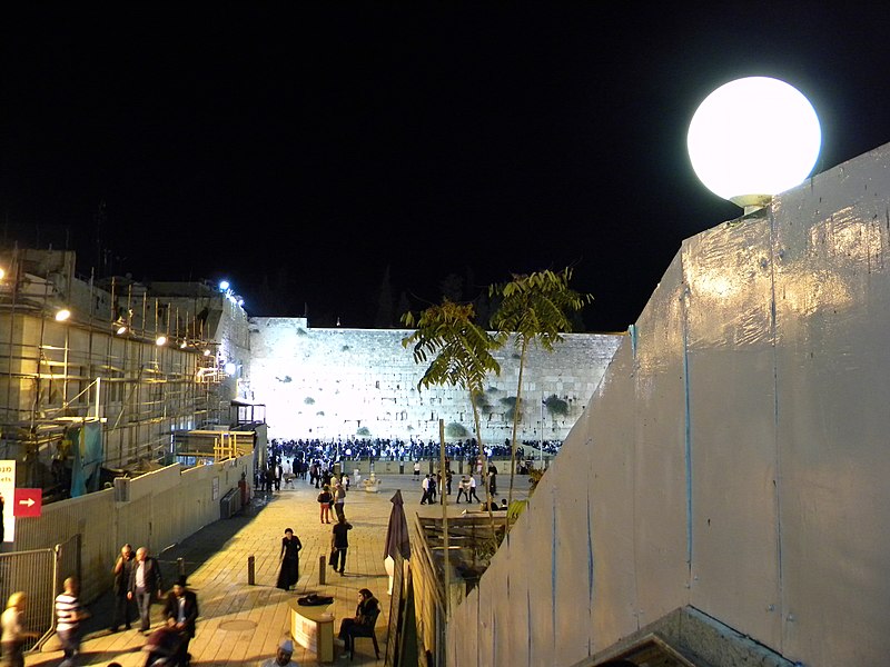 a round white light illuminating a vast walled area