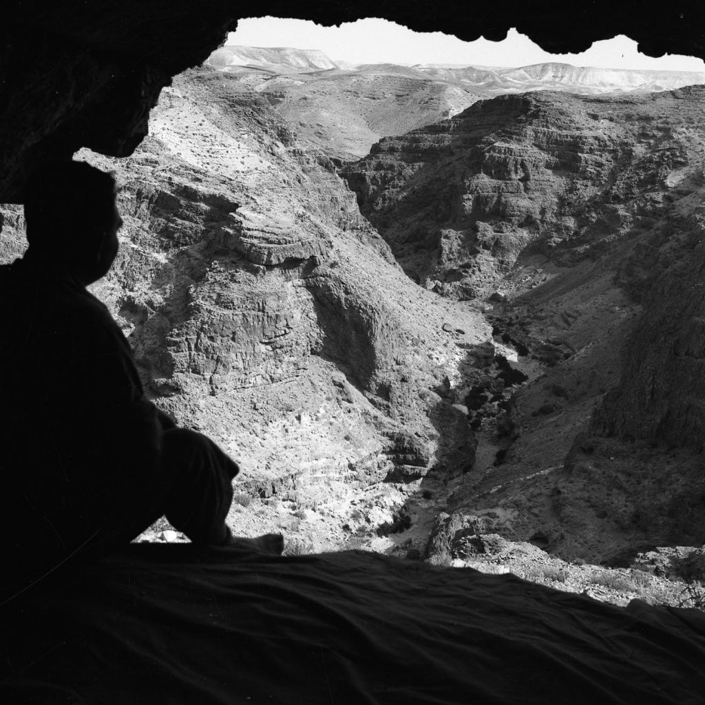 a silhouette of a man inside a cave