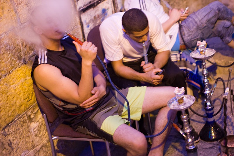 two men smoking from a pipe
