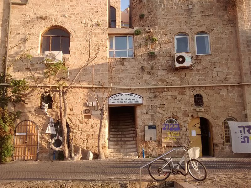 old weathered brown building with a bicycle in front