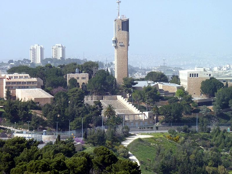a white tower surrounded by other buildings and trees