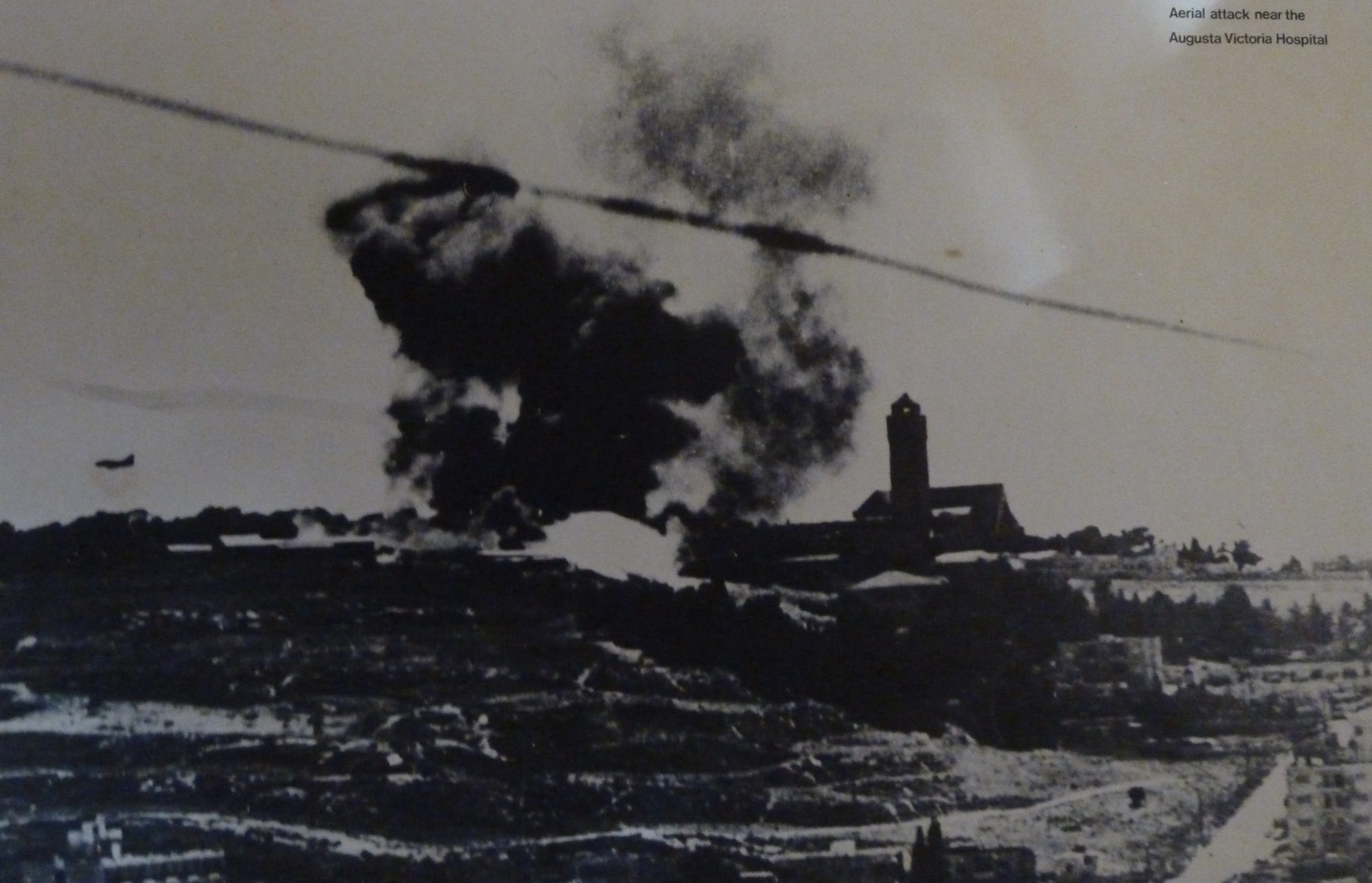 a black and white picture of an Israeli airstrike near the Augusta-Victoria Hospital