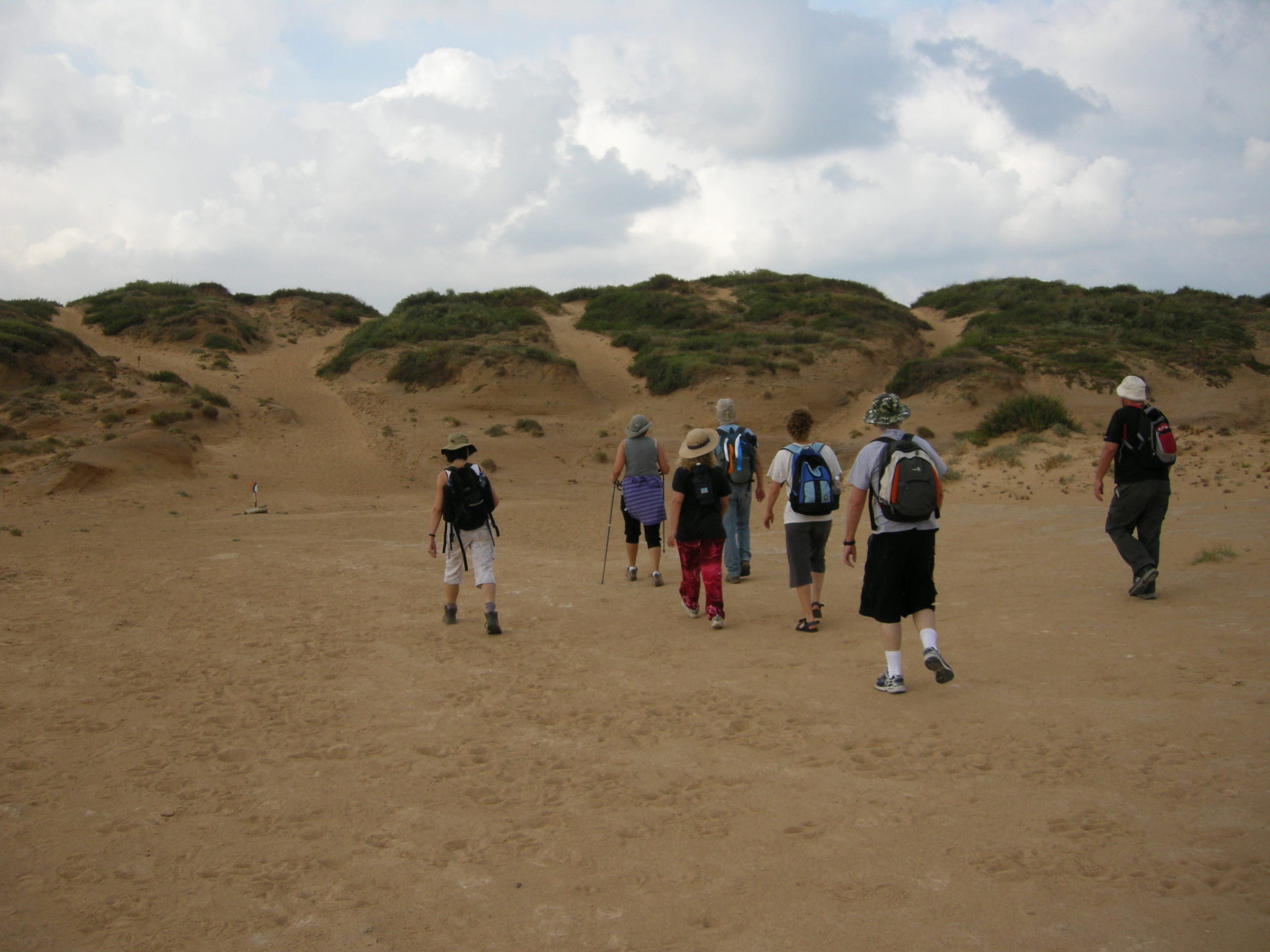 a group of hikers in an open sandy area