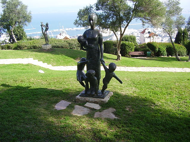a statue of mother and children at a park