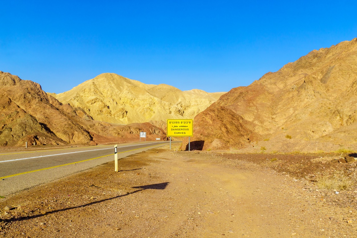 Desert road, with a warning sign